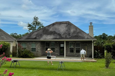 Technician performing soft wash on painted home exterior in daphne